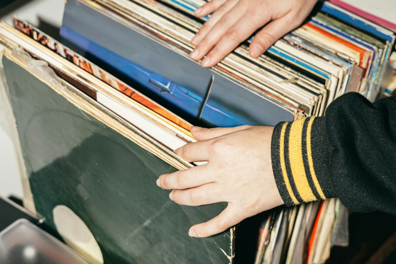 Person's hands searching through a record collection