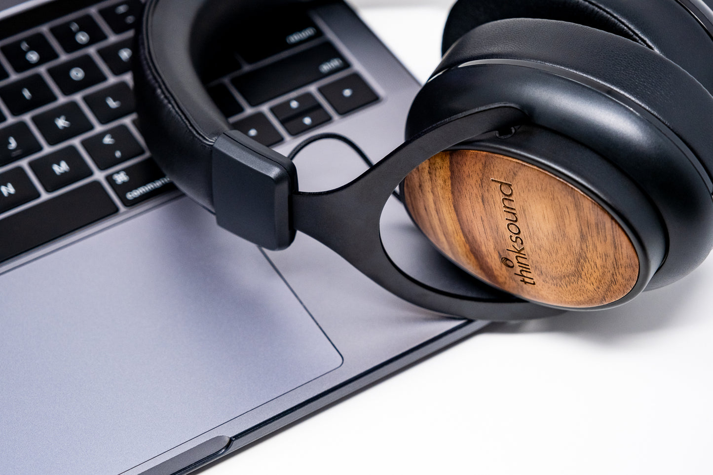Wooden over-ear headphones with 'thinksound' logo on a laptop