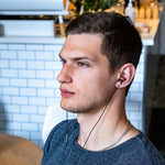 Load image into Gallery viewer, Guy wearing thinksound in20 headphones at a cafe
